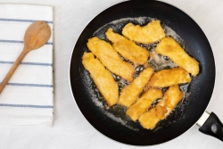 Chicken strips frying in a pan